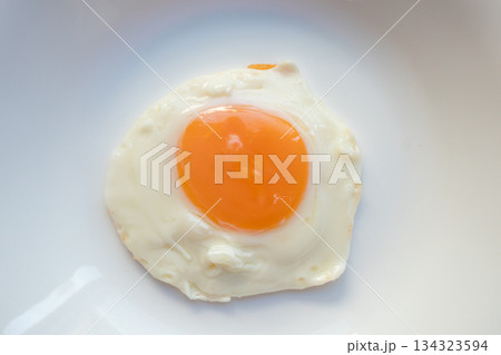 Fried egg on white dish close up 134323594