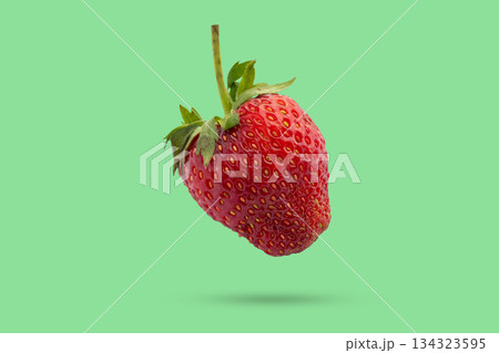 Fresh red strawberry flying on green background Fresh red strawberry flying on green background 134323595