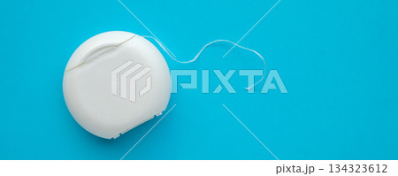 dental floss in case on blue background dental floss in case on blue background 134323612