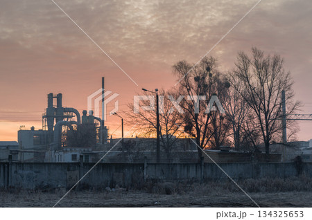 Morning glow over the plant. Fiery sky over the factory. Morning fog at the old factory. 134325653
