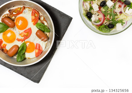 Scrambled eggs and salad. Fried eggs in the pan. 134325656
