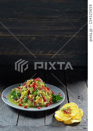 Salad decorated with pomegranate berries. Salads with pomegranate and chips. 134325659