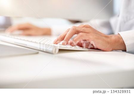 Close up of asian businessman's hands typing on keyboard at computer table in the company's office. Close up of asian businessman's hands typing on keyboard at computer table in the company's office. 134328931