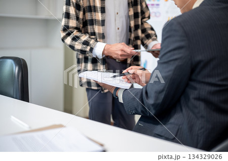 Close up of a man explaining document to businessman boss during work presentation in company office Close up of a man explaining document to businessman boss during work presentation in company office 134329026