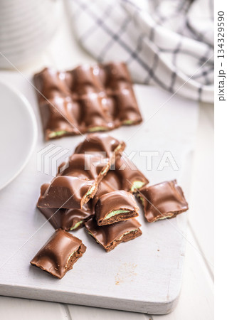 Chocolate bar with pistachios cream on white table. 134329590