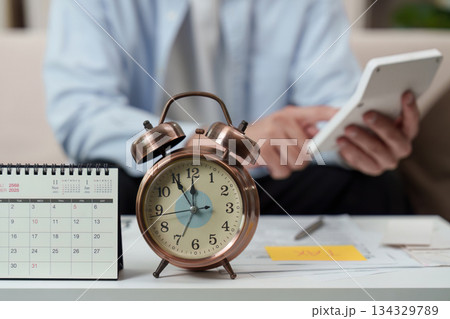 Time Management. Individual planning tasks with calendar and alarm clock on desk. 134329789