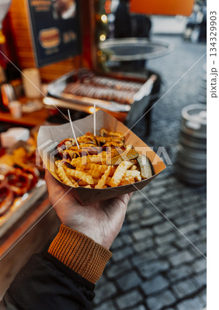 Currywurst and Fries in a Paper Tray at a European Street Food Market Currywurst and Fries in a Paper Tray at a European Street Food Market 134329903