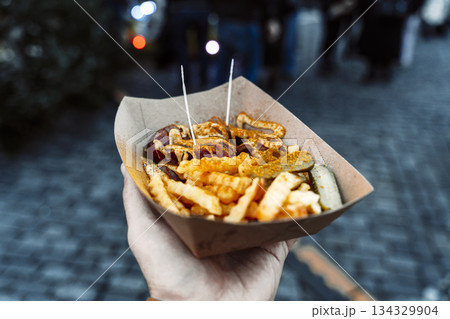 Currywurst and Fries in a Paper Tray at a European Street Food Market Currywurst and Fries in a Paper Tray at a European Street Food Market 134329904