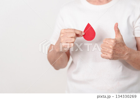 Elderly woman with red Blood drop paper for concept of June World Blood Donor day, Donation, January Blood donor awareness month, April Hemophilia awareness day, May Thalassemia Day, Anemia awareness Elderly woman with red Blood drop paper for concept of June World Blood Donor day, Donation, January Blood donor awareness month, April Hemophilia awareness day, May Thalassemia Day, Anemia awareness 134330269