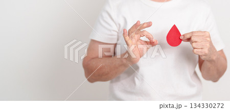 Elderly woman with red Blood drop paper for concept of June World Blood Donor day, Donation, January Blood donor awareness month, April Hemophilia awareness day, May Thalassemia Day, Anemia awareness 134330272