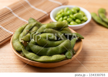 Boiled Edamame beans (Japanese soybeans) on wooden background Boiled Edamame beans (Japanese soybeans) on wooden background 134330703