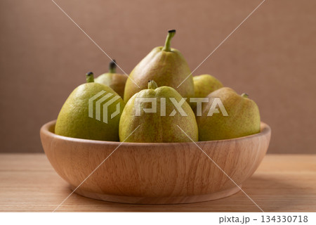 Fresh pear in a bowl on wooden background 134330718