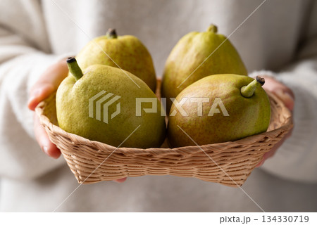Fresh pear in basket holding by woman hand Fresh pear in basket holding by woman hand 134330719