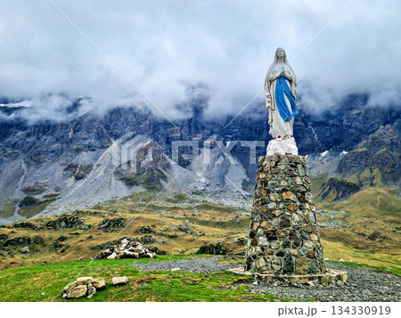 Blessed virgin Mary statue at Cirque de Troumouse, Heas in France. Meadows surrounded by dramatic mountain peaks Blessed virgin Mary statue at Cirque de Troumouse, Heas in France. Meadows surrounded by dramatic mountain peaks 134330919