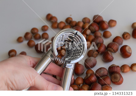 Woman holding a metal nutcracker in her hand Woman holding a metal nutcracker in her hand 134331323