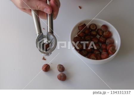 Male hand with nutcracker, separating the kernel from the shell Male hand with nutcracker, separating the kernel from the shell 134331337