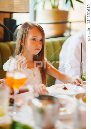 Girl sitting at a table during a meal with friends 134331619