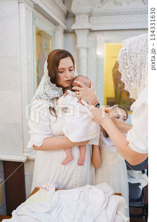 Family celebration during a baptism ceremony in a church Family celebration during a baptism ceremony in a church 134331630
