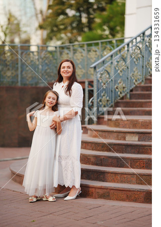 Mother and daughter enjoy a joyful moment outdoors Mother and daughter enjoy a joyful moment outdoors 134331659