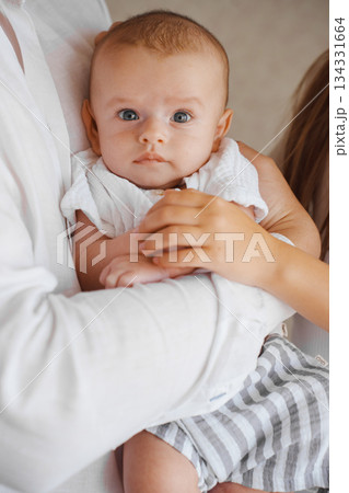 Baby being held by loving family members at home 134331664