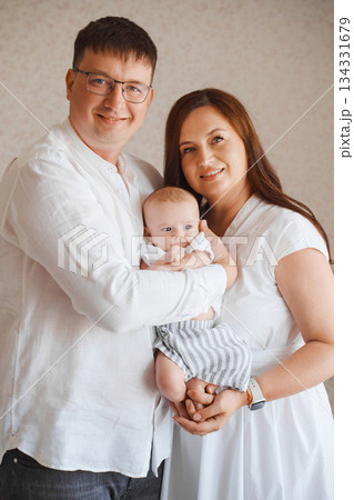 Loving family poses together with baby in peaceful setting Loving family poses together with baby in peaceful setting 134331679
