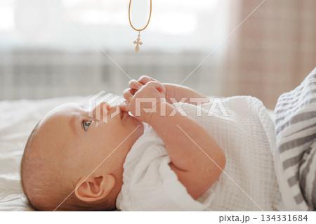 Baby gazing up at pendant hanging above crib Baby gazing up at pendant hanging above crib 134331684