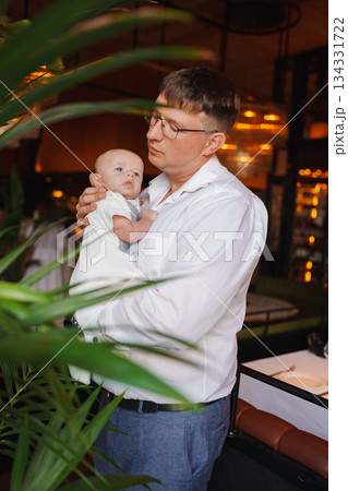 Father holding baby in cozy restaurant setting 134331722