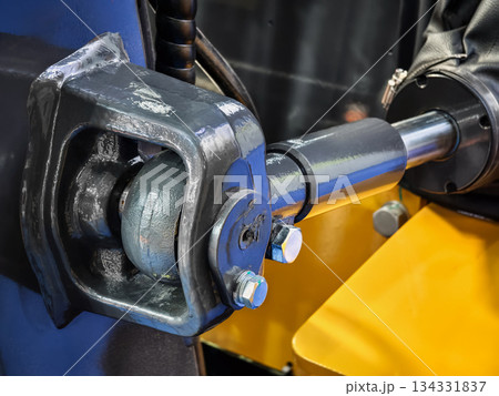 Close view of hydraulic machinery part showing connection and design in industrial setting during daytime Close view of hydraulic machinery part showing connection and design in industrial setting during daytime 134331837