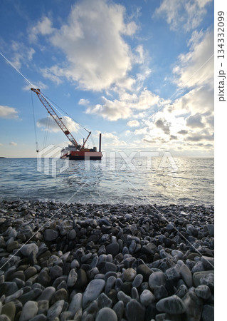 a dredge with crane dredging the sea bottom near the shore a dredge with crane dredging the sea bottom near the shore 134332099
