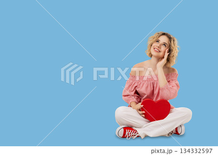 Valentine's Day is shown with a girl sitting on a blue backdrop 134332597