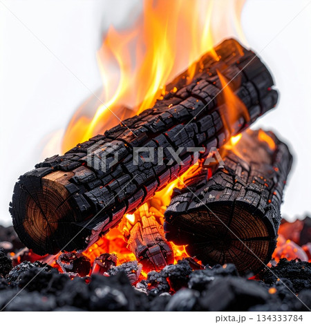 Burning Logs in Fire Emitting Orange Flames Over Bed of Coals 134333784