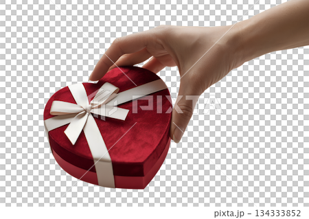 Person holding classic red heart-shaped gift box with white bow, symbolizing love, affection, and thoughtful presents for a special occasion 134333852
