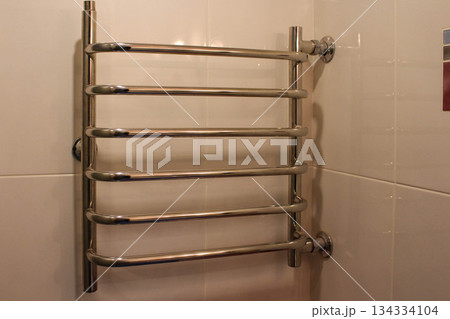 Chrome heating radiator on the wall in the bathroom 134334104