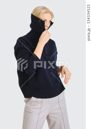 Model showcases stylish navy sweater in an indoor setting with modern design elements Model showcases stylish navy sweater in an indoor setting with modern design elements 134334525