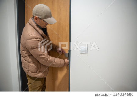 Man locking front door after returning home. Securing apartment and ending the day. 134334690