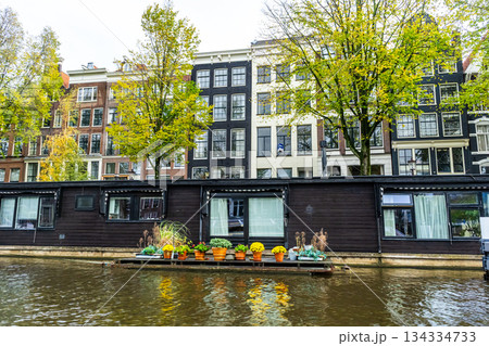 A floating house in Amsterdam canal. Boat home on water. Houseboat in Netherlands A floating house in Amsterdam canal. Boat home on water. Houseboat in Netherlands 134334733