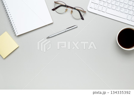 Organized workspace with stationery, keyboard, glasses and notebook creating productive atmosphere Organized workspace with stationery, keyboard, glasses and notebook creating productive atmosphere 134335392