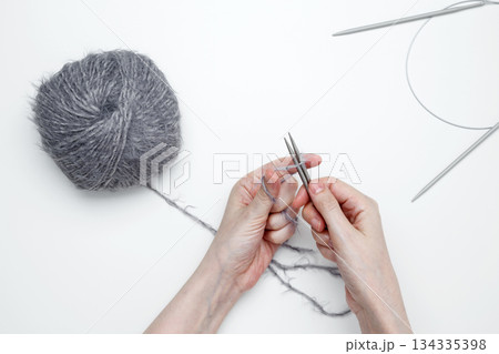 Woman knitting with needles creating handmade fabric Woman knitting with needles creating handmade fabric 134335398
