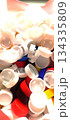 A close-up shot from above of a large pile of assorted plastic bottle caps, mostly white, with splashes of blue, yellow and red, suggesting recycling or sorting 134335809