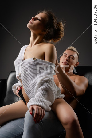 Couple sharing a tender moment in intimate lingerie setting at home Couple sharing a tender moment in intimate lingerie setting at home 134335906