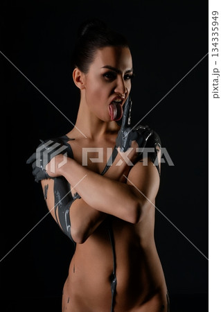 Woman expressing beauty through artistic body paint in dramatic lighting 134335949