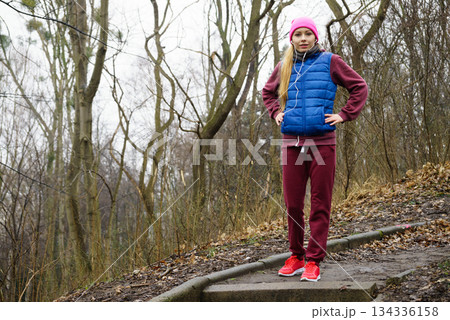 Woman wearing sportswear exercising outside during autumn Woman wearing sportswear exercising outside during autumn 134336158