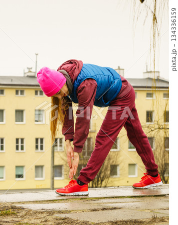 Sporty girl stretching outdoor on city street. 134336159