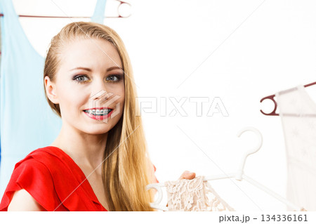 Woman in shop or wardrobe picking dress Woman in shop or wardrobe picking dress 134336161