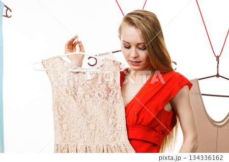 Woman in shop or wardrobe picking dress Woman in shop or wardrobe picking dress 134336162