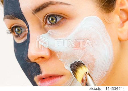 Girl black mask on half face apply white mud 134336444