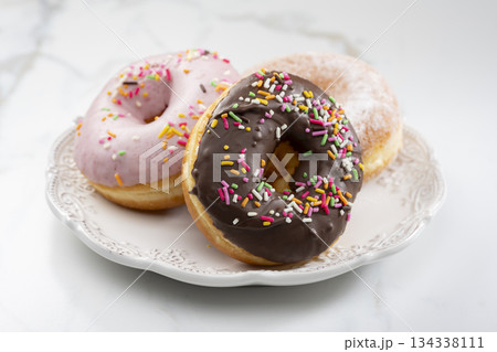 カラフルなトッピングが映えるチョコレートドーナツとスイーツ盛り合わせ 134338111