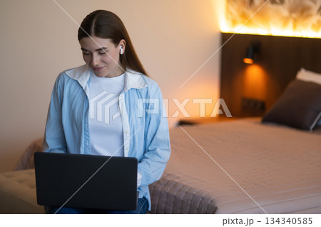 Pretty young woman in a hotel room with a laptop 134340585