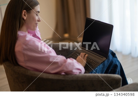 Pretty long-haired woman with a laptop in a hotel room Pretty long-haired woman with a laptop in a hotel room 134340598
