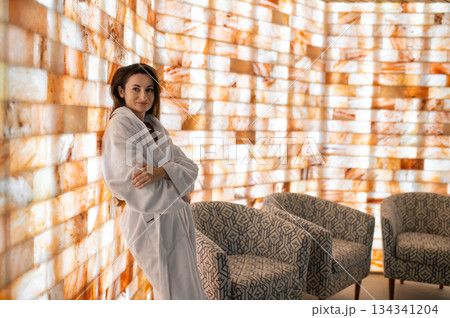 Pretty woman in white bath robe feeling relaxed and peaceful after spa procedures 134341204